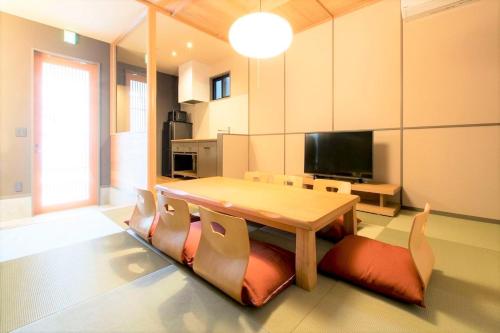 a living room with a wooden table and chairs at MUSUBI HOTEL MACHIYA Haruyoshi in Fukuoka