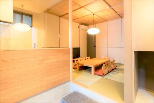 una sala da pranzo con tavolo e sedie in una stanza di MUSUBI HOTEL MACHIYA Haruyoshi a Fukuoka