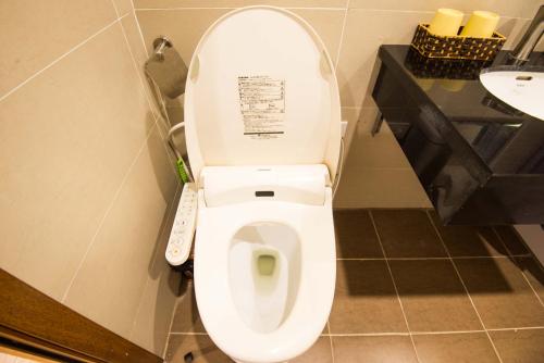 a white toilet with a remote control in a bathroom at 22Housing luxury Hotel & Residence 39 Linh Lang in Hanoi