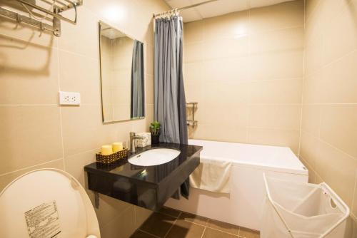 a bathroom with a sink and a tub and a toilet at 22Housing luxury Hotel & Residence 39 Linh Lang in Hanoi