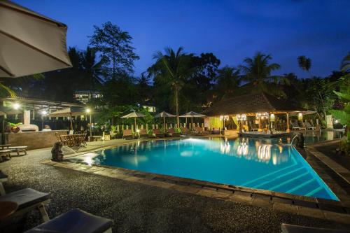 a swimming pool in a resort at night at Bali Spirit Hotel and Spa, Ubud in Ubud