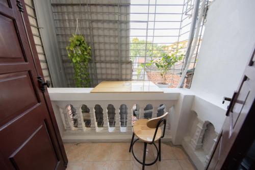 a chair sitting in front of a window with a table at Nusmile's Hostel and Travel in Hanoi