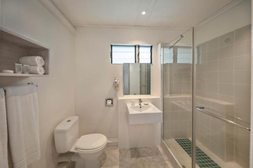 a bathroom with a toilet and a sink and a shower at Astroea Beach Hotel in Mahébourg