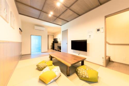 a living room with a wooden table and yellow chairs at 博多町家ホテル - Kamigofuku - in Fukuoka