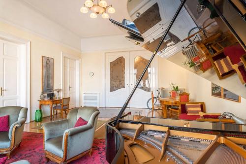 uma sala de estar com cadeiras e uma mesa de vidro em Stunning spacious art nouveau apart , grand piano em Budapeste