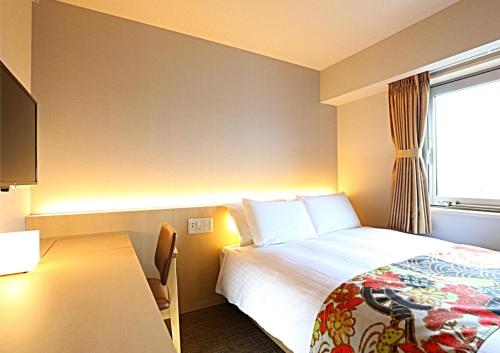 a hotel room with a bed and a window at Hotel Wing International Premium Kanazawa Ekimae in Kanazawa