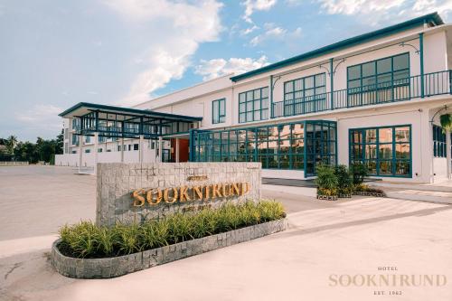 a large building with a sign in front of it at SOOKNIRUND HOTEL in Chiang Rai