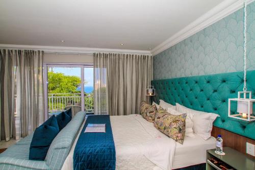 a bedroom with a large bed and a balcony at Sandals Guest House in Durban