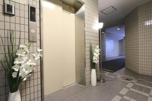 a bathroom with two vases with flowers in it at EG52 Elizabeth Garden in Osaka