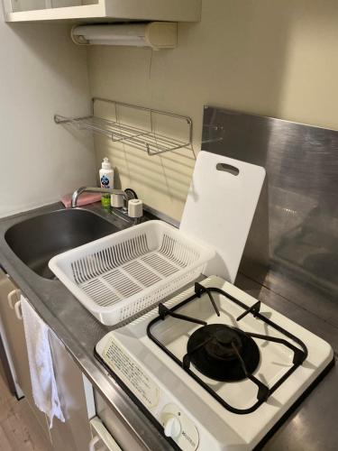 a kitchen counter with a stove and a sink at La Foret Fujimi in Hiroshima