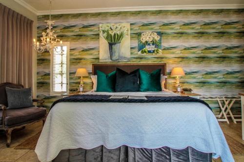 a bedroom with a large bed with green pillows at Sandals Guest House in Durban