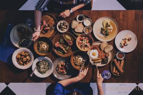 a group of people sitting at a table with plates of food at SOOKNIRUND HOTEL in Chiang Rai