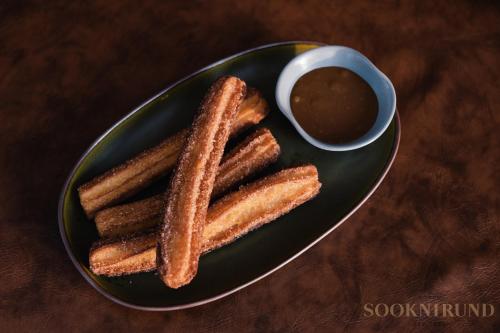a plate of cookies and a bowl of dipping sauce at SOOKNIRUND HOTEL in Chiang Rai