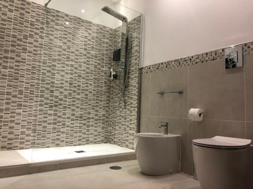 a bathroom with a shower and a toilet and a sink at B&B Rossini Luxury 2 in Cosenza