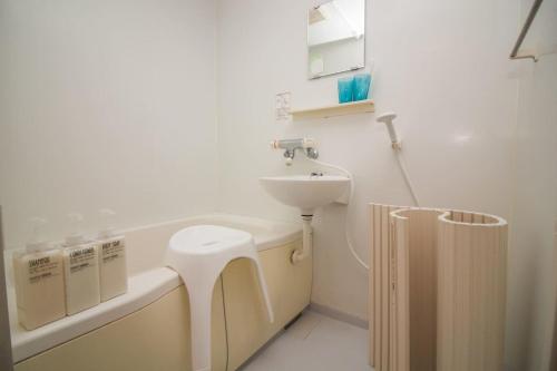 a white bathroom with a sink and a toilet at Nakayoshi Stay 401 in Osaka