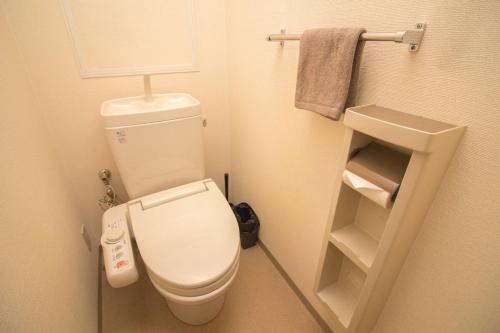 a small bathroom with a toilet and towels at Nakayoshi Stay 201 in Osaka