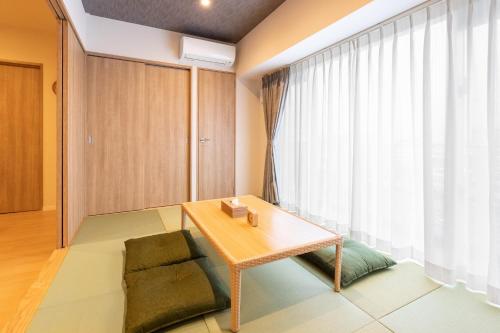 a room with a table and a chair and a window at LAPIN MIHAMA Residence Hotel in Chatan