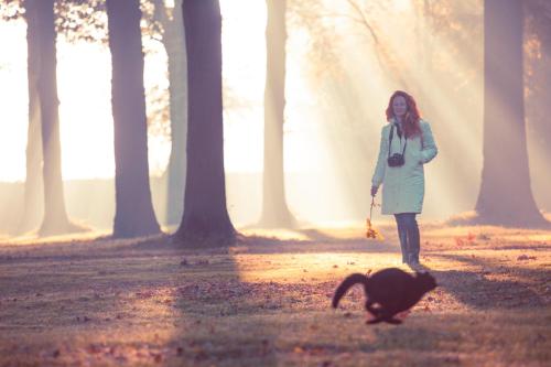 a woman walking a cat in a forest at Pałac Brunów - Wellness & SPA in Lwówek Śląski