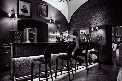 a man sitting at a bar in a restaurant at Pałac Brunów - Wellness & SPA in Lwówek Śląski