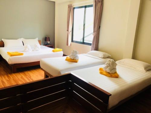 a room with two beds with towels on them at Sea Breeze Lodge Ngapali in Ngapali