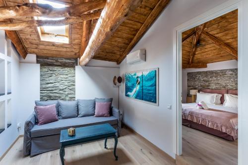 1 dormitorio con 1 cama y 1 sofá en una habitación en CAMARA SUITES, en Ándros