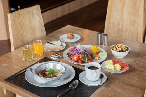 a wooden table with plates of food on it at The VELO'S Hotel and Pumptrack in Aranyaprathet