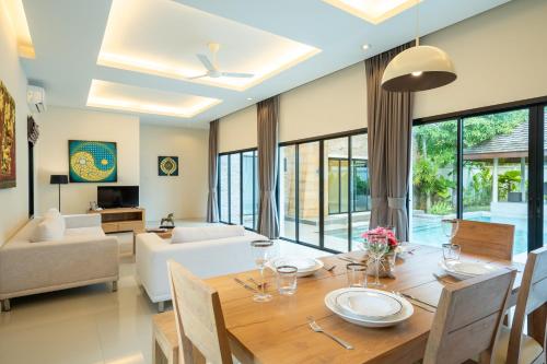a dining room and living room with a table and chairs at Layantara Villas in Layan Beach