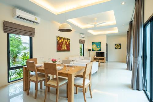 a dining room and living room with a table and chairs at Layantara Villas in Layan Beach