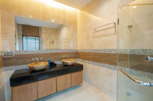 a bathroom with two sinks and a shower at Layantara Villas in Layan Beach