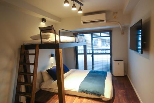 a bedroom with two bunk beds and a ladder at N33 Hakata Sta East in Fukuoka