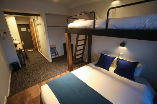 a bedroom with two bunk beds and a ladder at N33 Hakata Sta East in Fukuoka