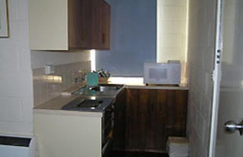a kitchen with a stove and a microwave at Pathfinder Motel in Melbourne