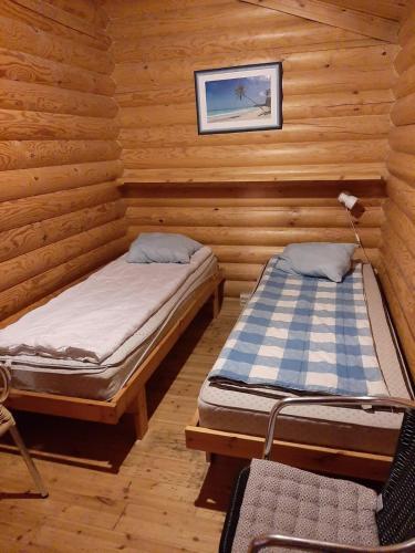 a room with two beds in a log cabin at Pankkotupa 65 "13А" in Savonlinna