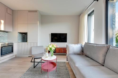 a living room with a couch and a table at Flamingo Beach Apartment in Gdańsk