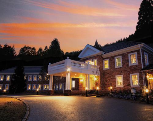 a building with a sunset in the background at Yufuin Hotel Mori-no-Terrace in Yufuin