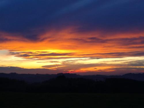 a sunset in the sky over a mountain range at Ferienbauernhof Koller (Familie Hofer) - Urlaub am Bauernhof in Helfenberg