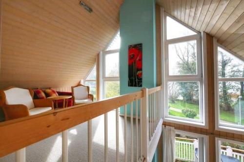 バート・ザーローにあるFerienpark Bad Saarowのソファと窓のある階段付きの客室です。