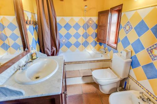 a bathroom with a sink and a toilet and a tub at La casita del Rincón in Arona