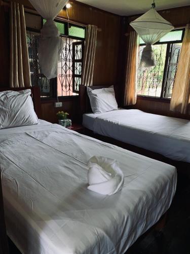 a room with two beds with a hat on it at Dalom Guesthouse in Don Det