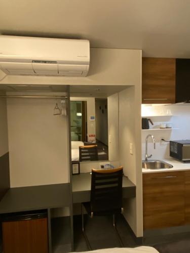 a kitchen with a sink and a counter top at Hotel 草石庵 in Osaka