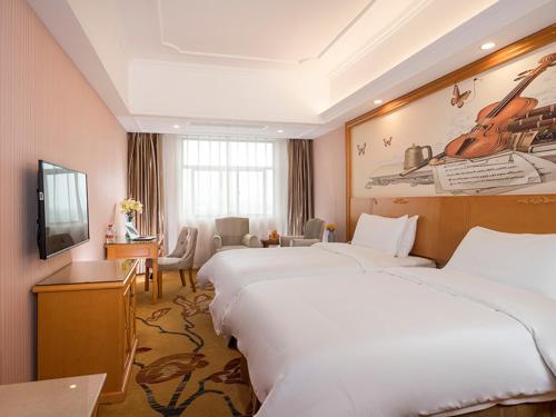 ein Hotelzimmer mit 2 Betten und einem TV in der Unterkunft Vienna Hotel (Tianyang Old City High Speed Railway Station) in Baise