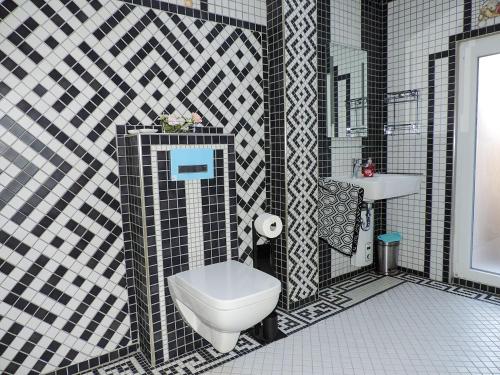 uma casa de banho em preto e branco com um WC e um lavatório em Stilvolles Ferienhaus Artdeco em Wernigerode