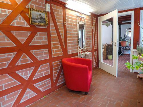 a red chair in a room with a brick wall at Stilvolles Ferienhaus Artdeco in Wernigerode