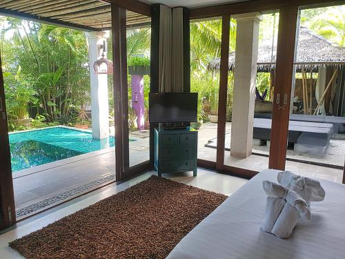 a bedroom with a bed and a television and a pool at Zen Villas in Bophut 