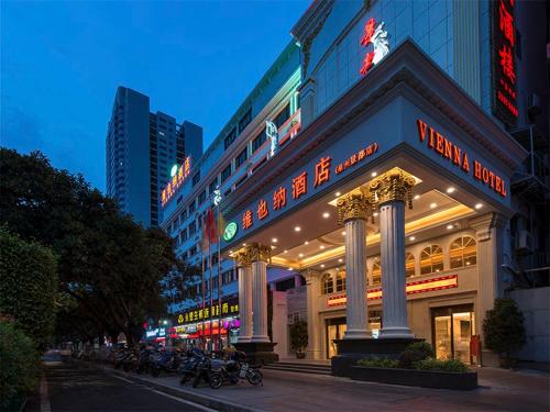 a building with a sign on the side of a street at Vienna Hotel (Quanzhou Bus Station) in Quanzhou