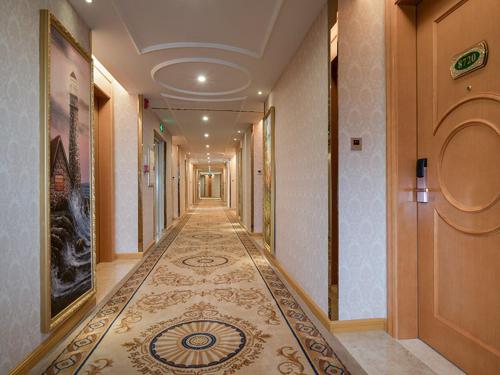 um corredor de um edifício com piso em azulejo em Vienna Hotel (Shaoguan Lechang Branch) em Lechang