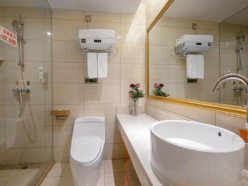 a bathroom with a sink and a toilet and a mirror at Vienna Hotel 3 best Wuwei City south in Wuhu