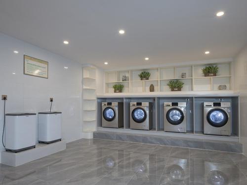 a room with three washing machines in a building at Venus Royal Hotel(Foshan Kuiqi Road Metro Station) in Foshan