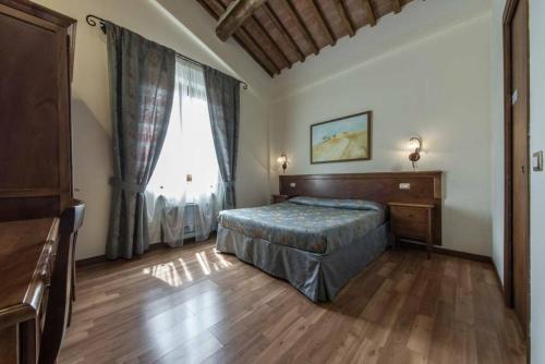 a bedroom with a bed and a large window at Fonte Dei Tufi in Siena