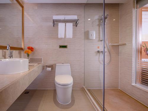 La salle de bains est pourvue de toilettes, d'un lavabo et d'une douche. dans l'établissement Vienna International Hotel (Shenzhen Fuyong Convention and Exhibition Center), à Fenghuangwei